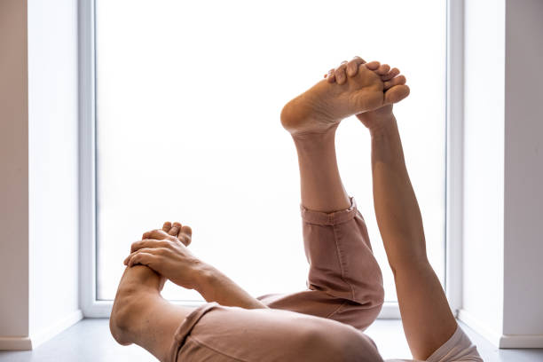 A woman sitting on an armchair stretches muscles. Health and sport concept.