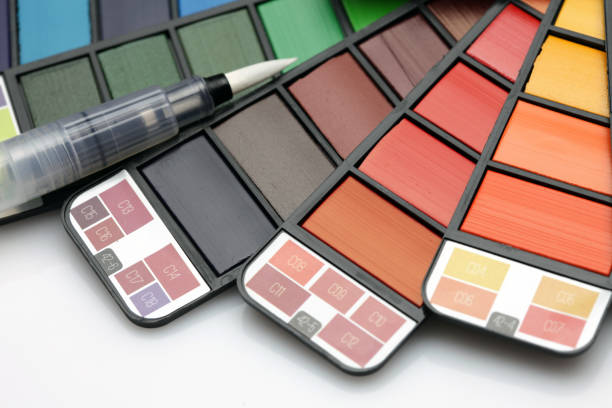 istock Watercolor paint rainbow palette with brush on white texture paper. 1358233402