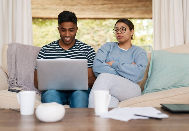 istock Shot of a young couple discussing their bills while using a laptop 1358236226