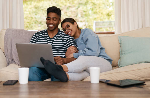 istock Shot of a young couple hanging out together while using a laptop 1358236238
