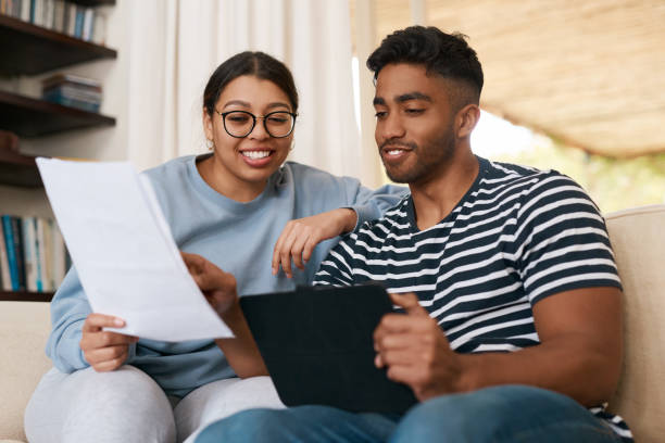 istock Shot of a young couple discussing their bills while using a digital tablet 1358236253