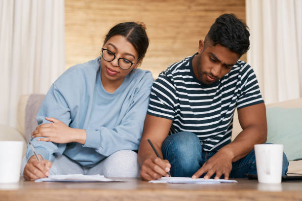 istock Shot of a young couple signing documents together 1358236264