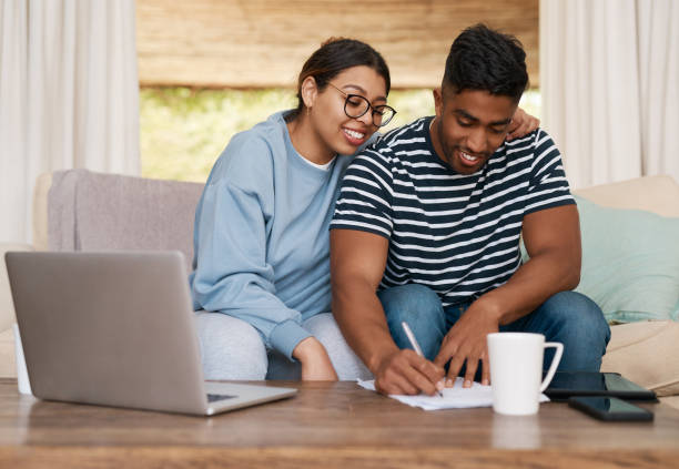 istock Shot of a young couple signing documents together 1358236270