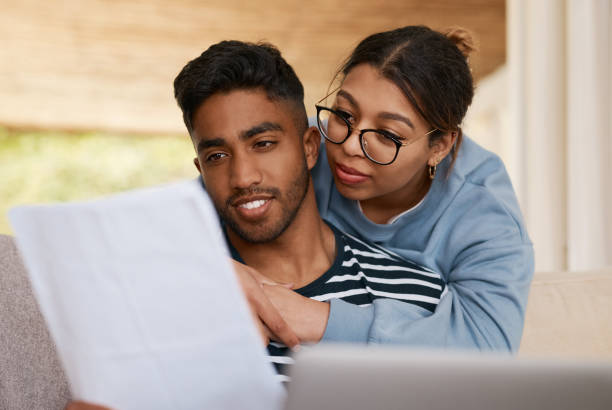 istock Shot of a young couple discussing bills while using a laptop 1358236287