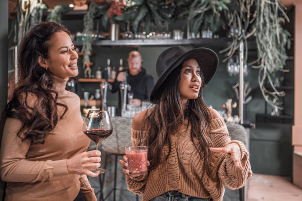 istock Happy friends sharing indoor drinks in a restaurant setting 1358237175