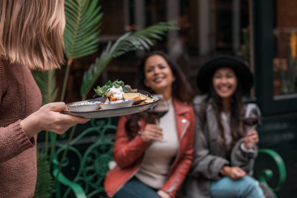 istock Happy friends sharing al fresco drinks in a restaurant setting 1358237628