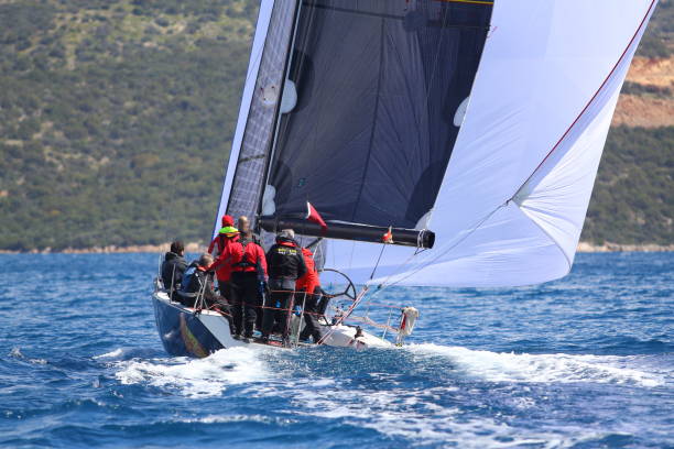 segelboote segeln bei windigem wetter im blauen wasser der ägäis - sailboat storm teamwork competition stock-fotos und bilder