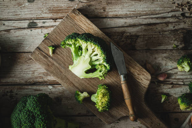 istock Knife and sliced fresh broccoli on a wooden cutting board 1358239178
