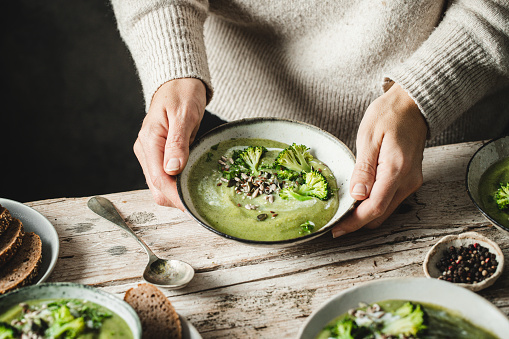 Homemade broccoli being served by a woman