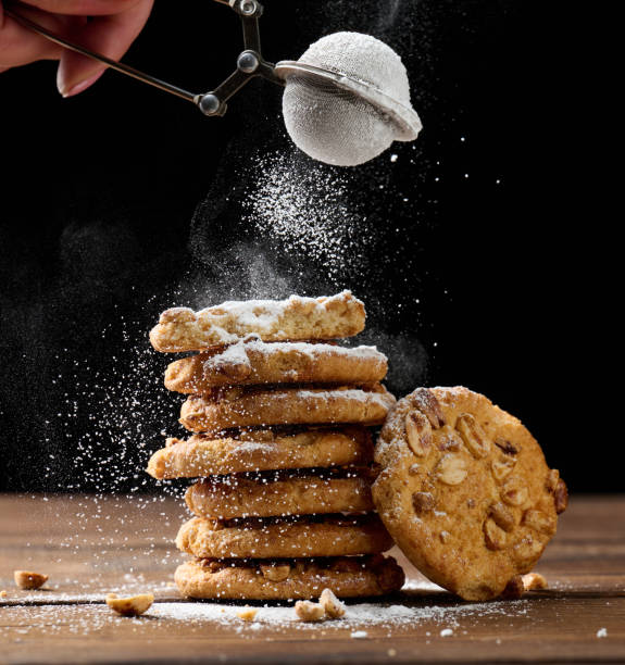 istock a stack of baked round cookies sprinkled with powdered sugar on a wooden table, black background 1358239366