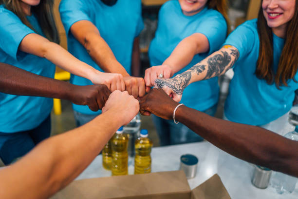 istock Volunteers show unity with group fist bump 1358240204