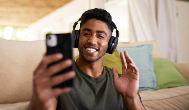 istock Shot of a young man using a phone at home 1358246134