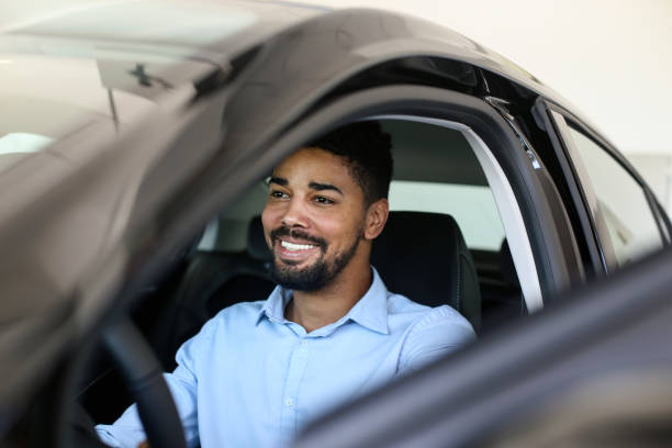 klient płci męskiej testujący samochód w salonie dealerskim - car african descent shopping car dealership zdjęcia i obrazy z banku zdjęć