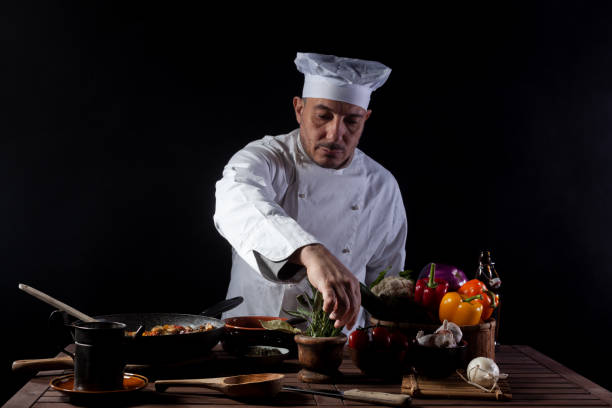 istock Male cook in white uniform and hat while working in a restaurant kitchen 1358248167