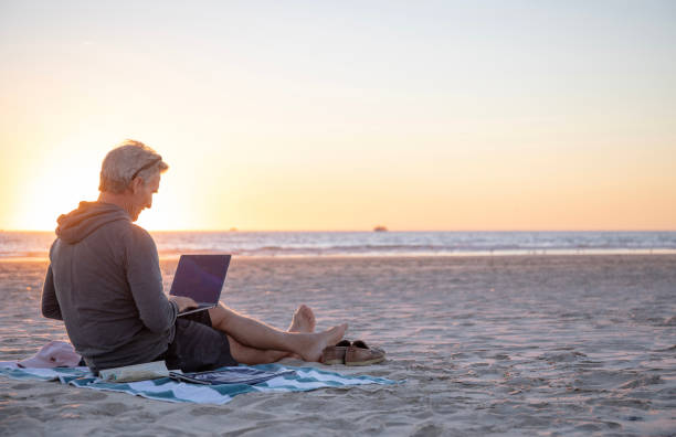 istock Man relaxes on sandy beach at sunrise 1358249944