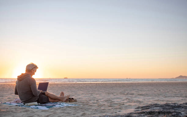 istock Man relaxes on sandy beach at sunrise 1358249953