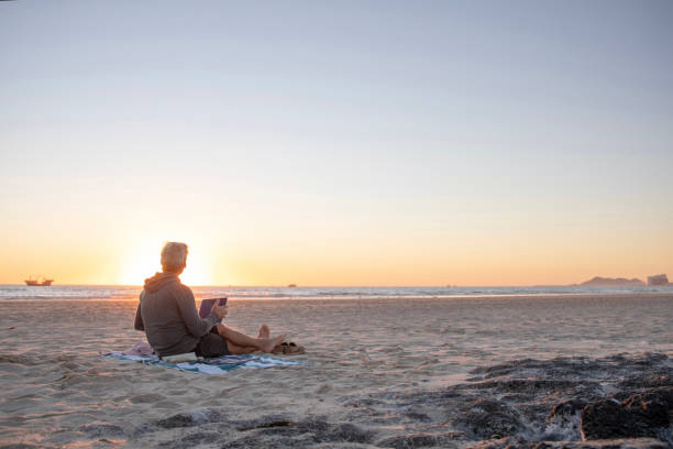 Man relaxes on sandy beach at sunrise