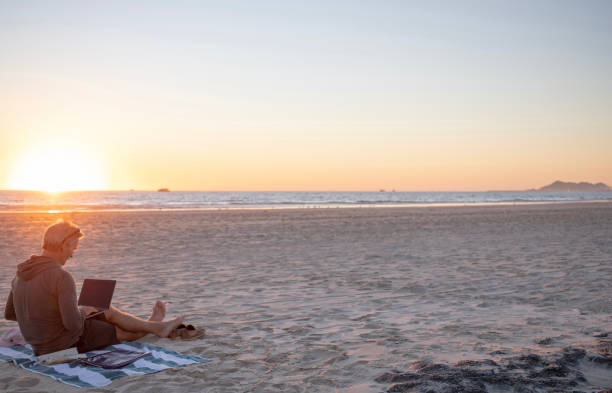 istock Man relaxes on sandy beach at sunrise 1358249995