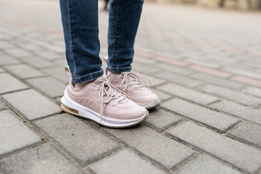 Man in jeans and sneakers walking on city street, closeup. Space for text