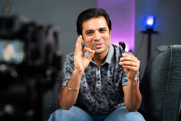 Young Indian influencer explaining about derma roller and its usage by recording on camera at Home - concept of skin care and fairness tips from social media.