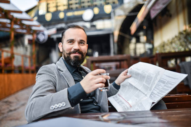 Smiling Businessman Drinking Turkish Tea While Reading Morning Newspaper