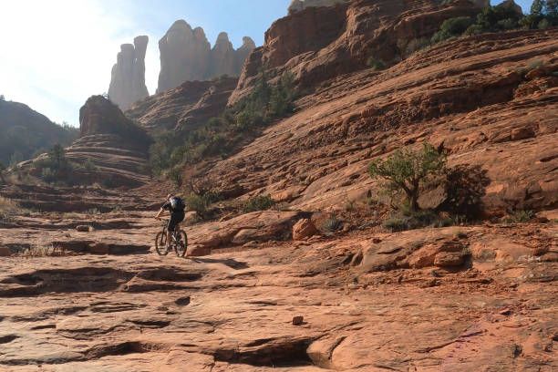 istock Mountain biker follows trail down rock slab 1358253456