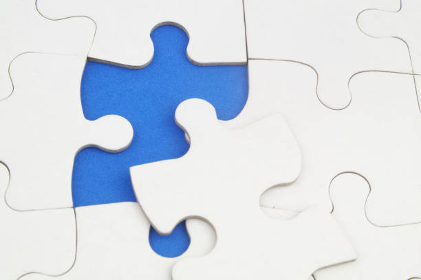 istock White jigsaw puzzles background, one piece missing and ready to connecting. 1358253904