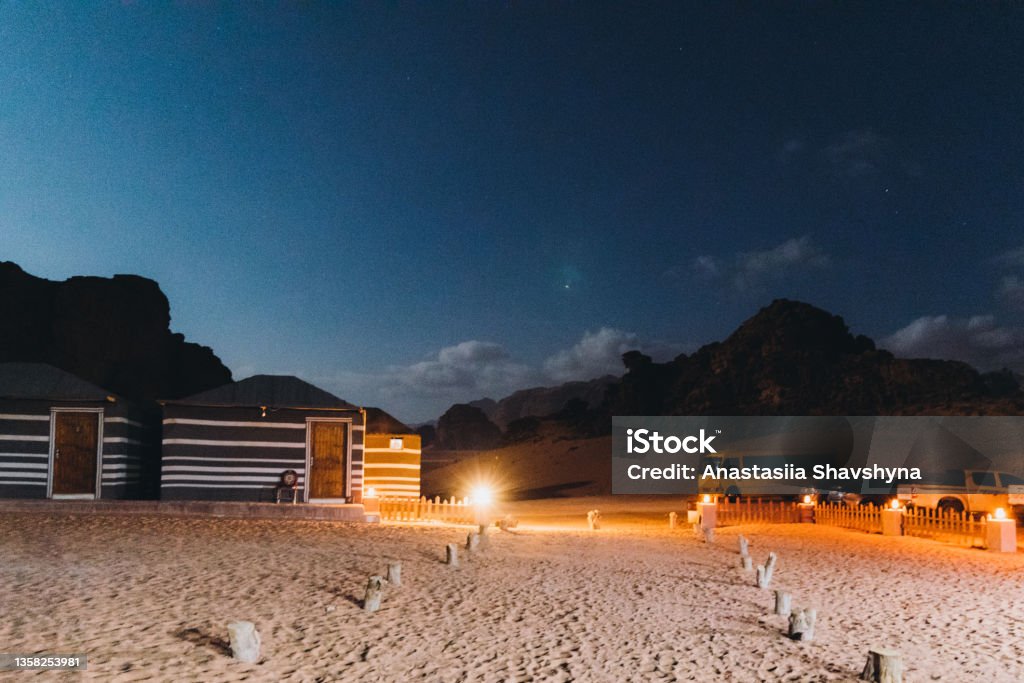 Magical night at the bedouin camp between the rocks in Wadi Rum desert Scenic view of the night campsite with lights hidden in the rocks in the desert of Jordan Wadi Rum Stock Photo