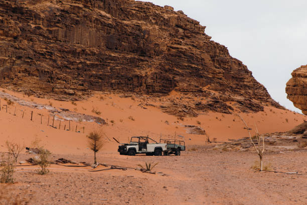 old abandoned car hidden in the sands of wadi rum desert - pick up truck red old 4x4 imagens e fotografias de stock