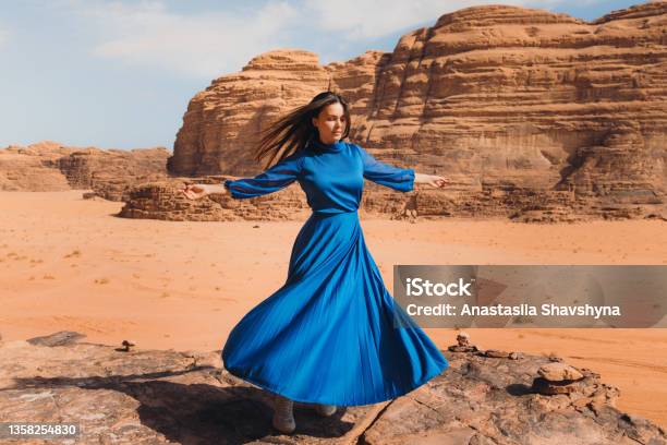 Woman In Blue Dress Contemplating The Scenic Landscape Of Wadi Rum Desert Stock Photo - Download Image Now