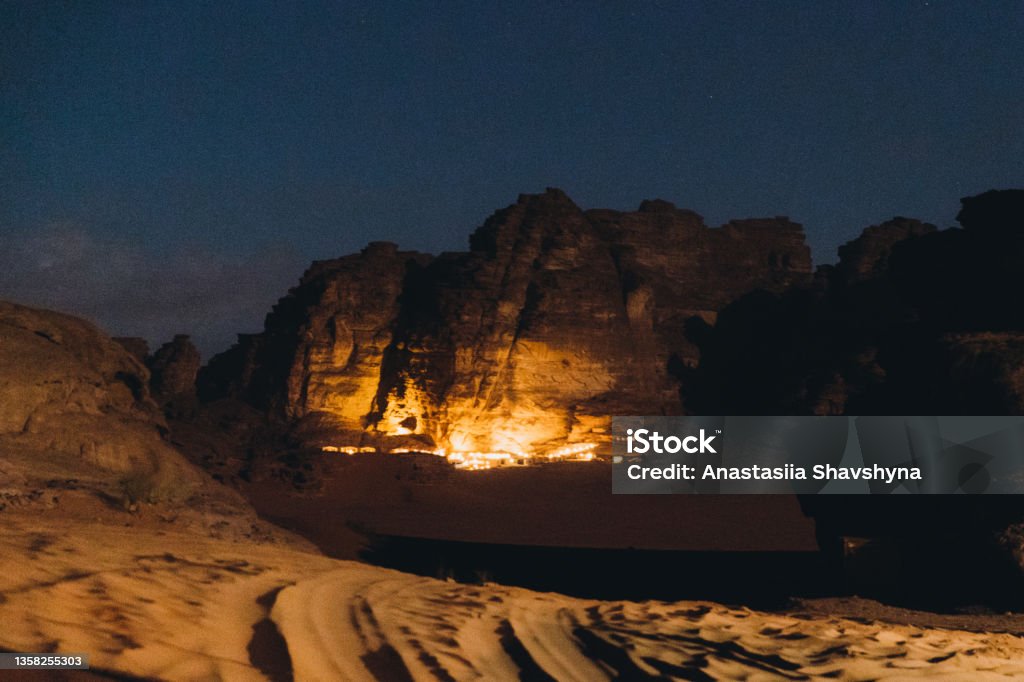 Magical night at the bedouin camp between the rocks in Wadi Rum desert Scenic view of the night campsite with lights hidden in the rocks in the desert of Jordan Adventure Stock Photo
