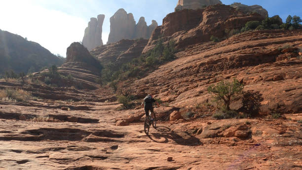 istock Mountain biker follows trail down rock slab 1358255735