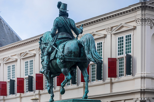 The Hague, Netherlands - February 4, 2021: exterior of Noordeinde Palace, since 2013 used as the working palace for King Willem-Alexander, seen from the publicly accessible shopping street