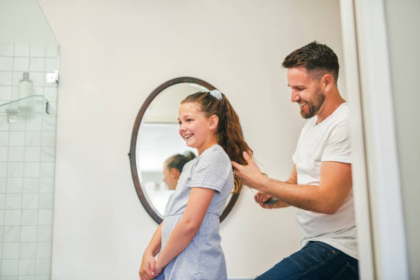 Shot of a single dad combing his daughters hair at home We'll be late if dad does my hair every day human hair women brushing beauty stock pictures, royalty-free photos & images