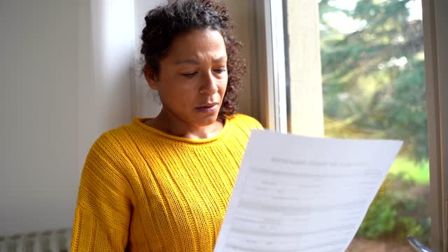 Video about worried woman reading bad news letter at home