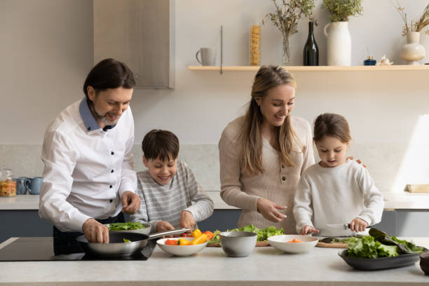 istock Happy parents cooking with small children at home. 1358265976