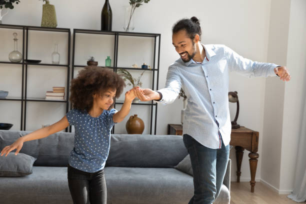 istock Happy little African American kid dancing with father. 1358266004
