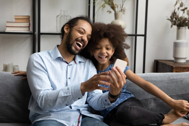 istock Happy African American family using cellphone at home. 1358266025