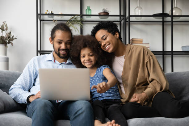 istock Happy African American family using computer at home. 1358266031