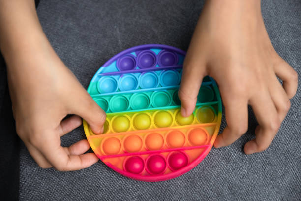 istock Close up African American kid playing with pop it toy. 1358266038