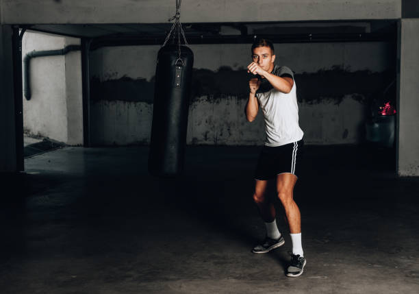 istock Young muscular sports guy practicing boxing 1358266739