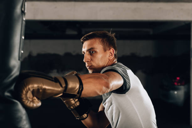 istock Dramatic lighting on a martial arts fighter punching in the gym 1358267056