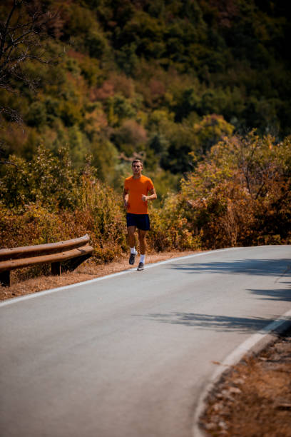 istock Fitness man running on highway around the mountains 1358268332