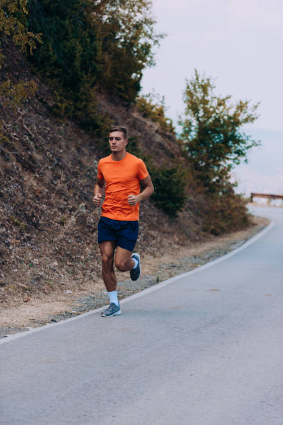 istock Sprinting runner man running at fast speed. Male sport sprinter training hard 1358268336