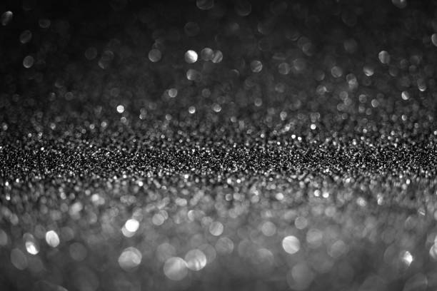 istock Black glitter lights. Shiny sparkles, bokeh effects, glowing surface. Selective focus, christmas abstract background 1358269420