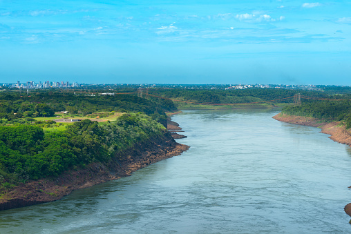 Parana river in the border of Brazil and Paraguay with a distant skyline view Paraguayan city of Ciudad del Este.