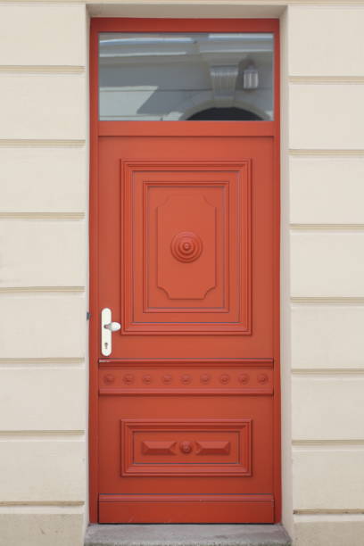 istock A decorated, red lacquered front door in front of a white background 1358270664