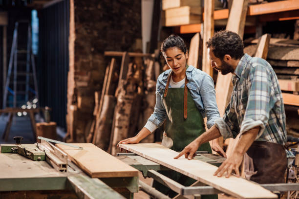 Discussing What's Best Carpenter and his apprentice working with sustainable locally sourced wood in a workshop in the North East of England. They are making handcrafted furniture and they are a family business. carpentry stock pictures, royalty-free photos & images