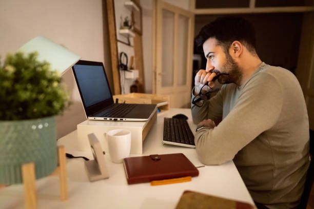 istock Worried male student e-learning late at night 1358273749