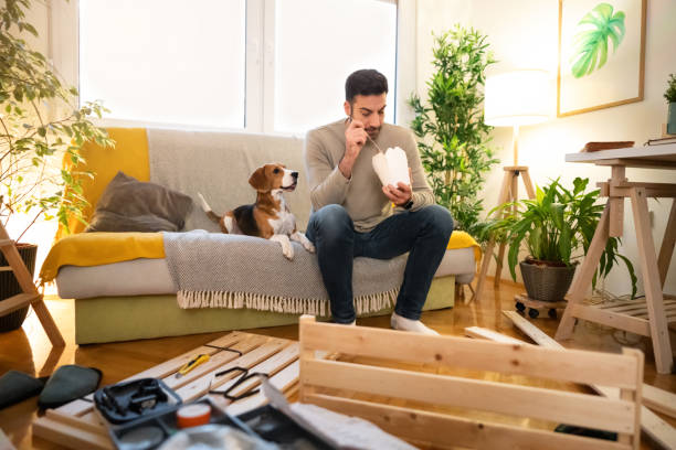 istock Caucasian man eating the take out food be ordered, while taking a break from home improvement 1358273823